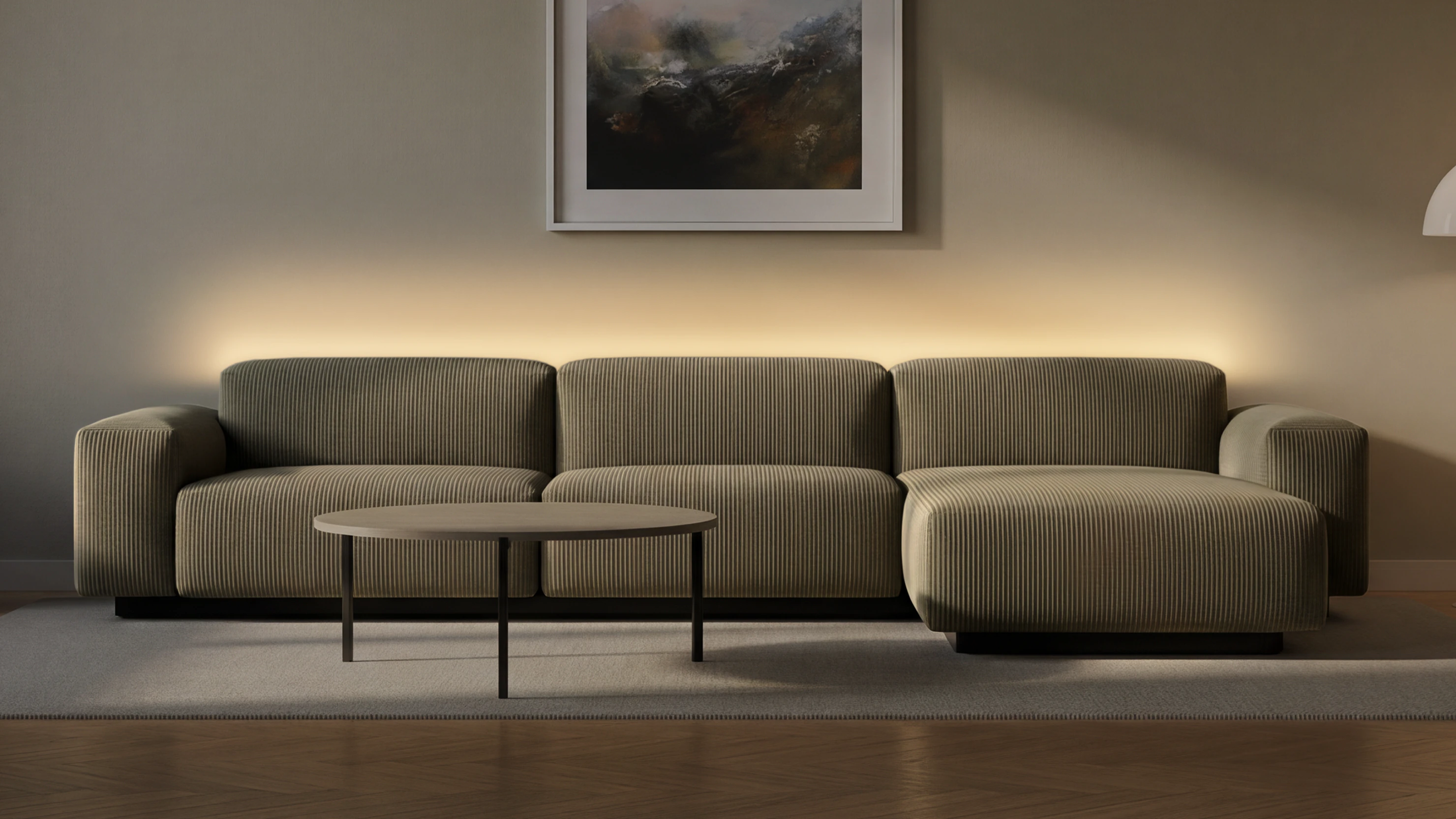 Durchgehender warmer Lichtschein an der Wand hinter dem Sofa, Lichtquelle verborgen – Licht wie aus der Wand